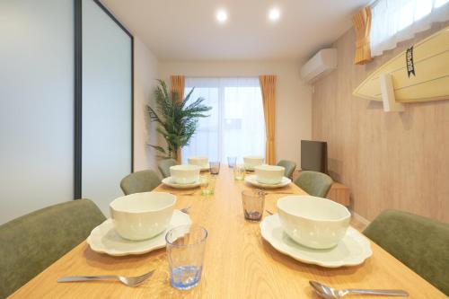 a dining room table with bowls and plates on it at Z LAND Enoshima in Fujisawa