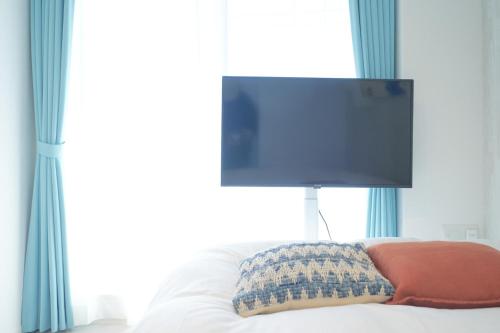 a bedroom with a bed with a flat screen tv at Z LAND Enoshima in Fujisawa