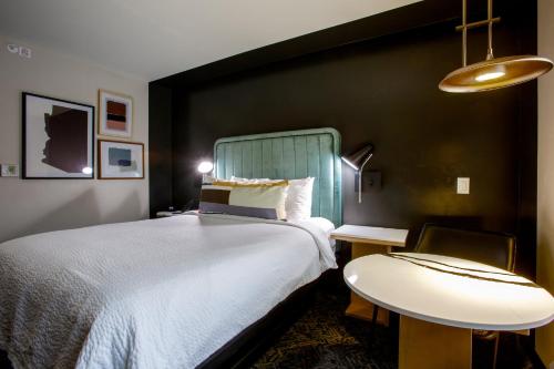 a bedroom with a large bed and a table at voco Flagstaff by IHG in Flagstaff