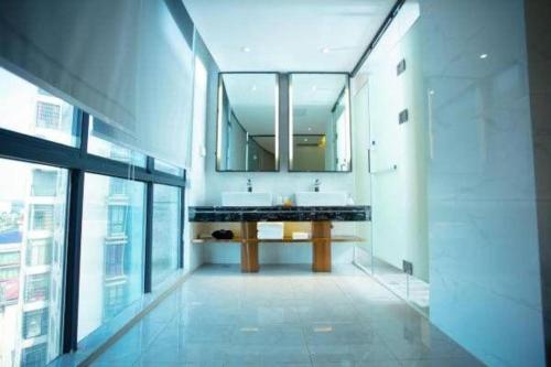 a bathroom with two sinks and a large mirror at Kyriad Marvelous Hotel Xiangyin Bus Station in Xiangyin
