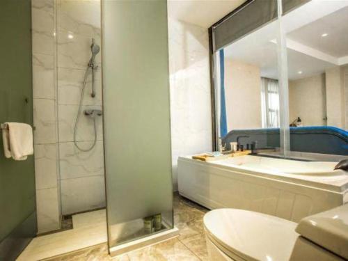 a bathroom with a shower and a toilet and a sink at Kyriad Marvelous Hotel Xiangyin Bus Station in Xiangyin