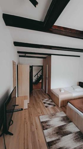 a living room with a bed and a wooden floor at Vila Silvana in Moieciu de Jos