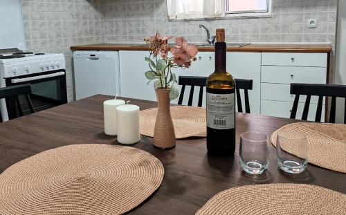 a bottle of wine sitting on a wooden table with a bottle of wine at Konstantina's cottage Ideal BaseforBalos & Elafonisi in Kissamos