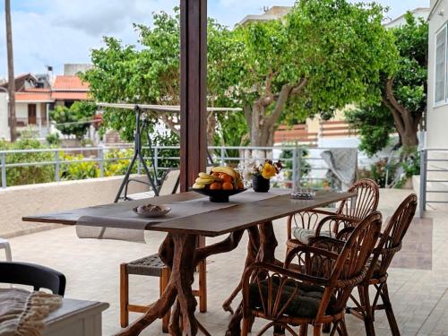 a wooden table and chairs on a patio at Konstantina's cottage Ideal BaseforBalos & Elafonisi in Kissamos