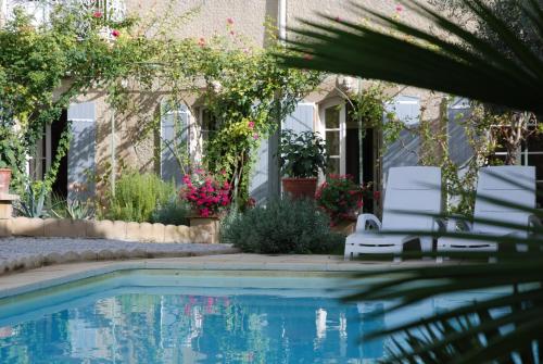 una casa con una piscina con 2 sillas junto a ella en B&B Coup de Coeur, en Bram
