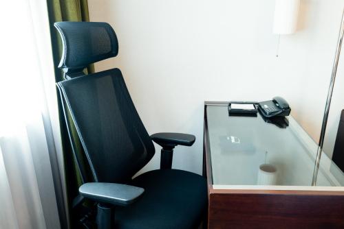 a black chair in a room with a mirror at Richmond Hotel Kagoshima Tenmonkan in Kagoshima