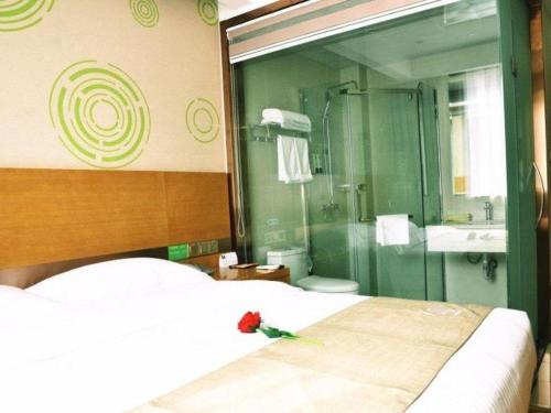 a bedroom with a bed and a glass shower at GreenTree Inn Xuzhou Ruojia Express Hotel in Xuzhou