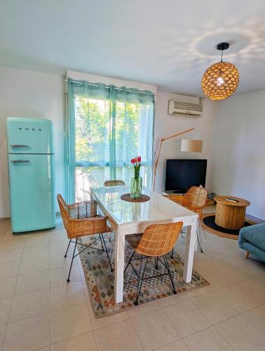 un salon avec une table et des chaises blanches dans l'établissement L'instant sorgue, à LʼIsle-sur-la-Sorgue