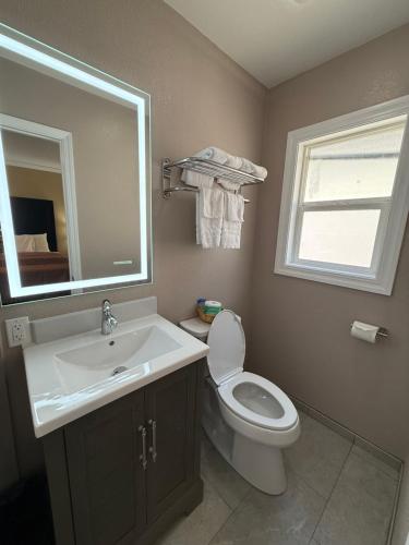 a bathroom with a sink and a toilet and a mirror at Tahoe Sands Inn in South Lake Tahoe