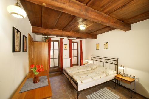 1 dormitorio con cama y techo de madera en Penzion Tilia, en Český Krumlov