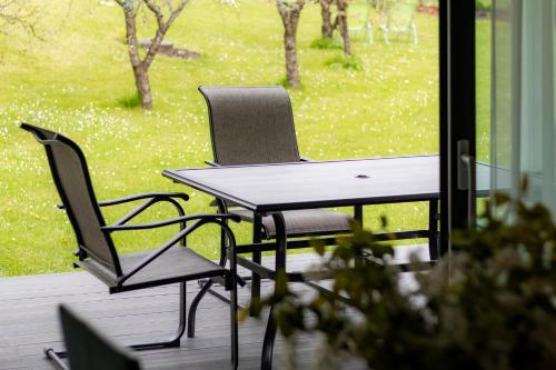 two chairs and a table on a porch with a window at Greenland House in Cēsis