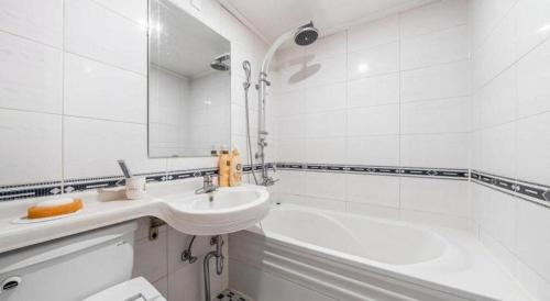 a white bathroom with a sink and a bath tub at Chuncheon World Hotel in Chuncheon