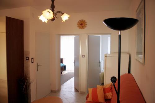 a living room with a couch and a lamp at Apartments Nada in Pag