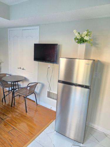 een roestvrijstalen koelkast in een keuken met een tafel bij Beautiful Studio with Patio in Mississauga in Mississauga