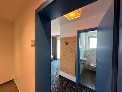 a bathroom with a toilet and a doorway at Partyhouse HARAKIRI stay DIFFERENT 60 seconds to MOUNTAINS! Free PARKING! Self CHECK-IN in Mayrhofen