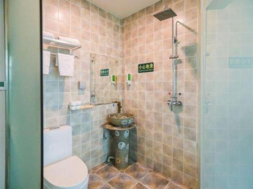 une salle de bain avec toilettes et douche dans l'établissement Beijing Wanjia Traders Hotel, à Pékin