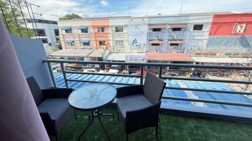 a balcony with a table and chairs and a pool at Chalong Paradise Guesthouse in Ban Bang Chak