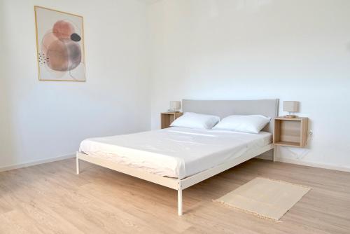 a white bed in a white room with a picture at Ivano & Franko apartments in Kruševo