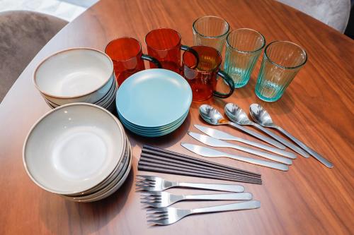 a table with plates and utensils on a table at Flat K Plum Umegaoka in Tokyo