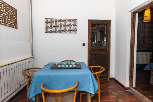 a dining room with a blue table and chairs at Elsewhere Hotel The former residence of the draft bank in Pingyao