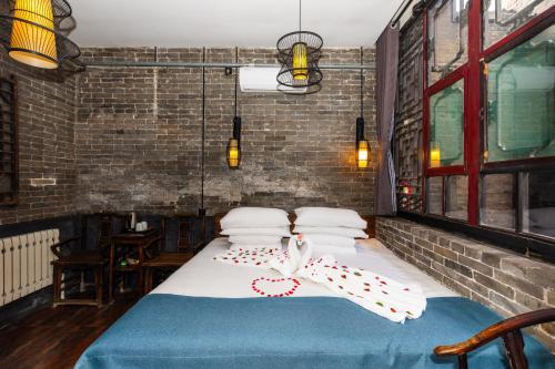 a bedroom with a bed in a brick wall at Elsewhere Hotel The former residence of the draft bank in Pingyao