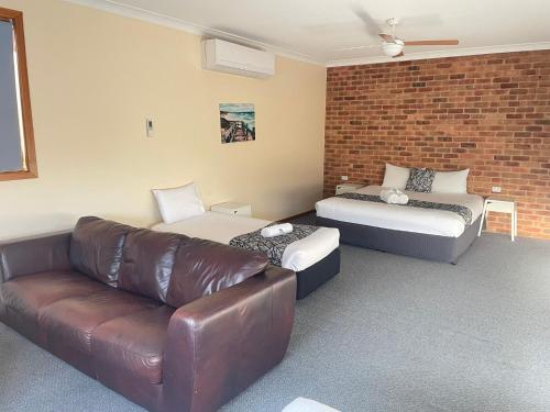 a living room with a couch and a bed at Coastal Bay Motel in Coffs Harbour