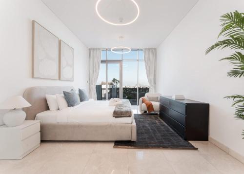 a white bedroom with a bed and a couch at Free housekeeping visits during your stay - StayShort - Stunning Sea View Escape at Anwa by Omniyat in Dubai