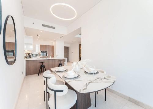 a kitchen and dining room with a table and chairs at Free housekeeping visits during your stay - StayShort - Stunning Sea View Escape at Anwa by Omniyat in Dubai