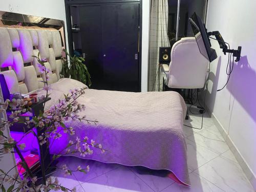 a purple room with a bed and a chair at Vista espectacular in Medellín
