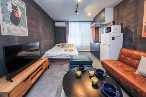 a living room with a couch and a table at Flat K Plum Umegaoka in Tokyo