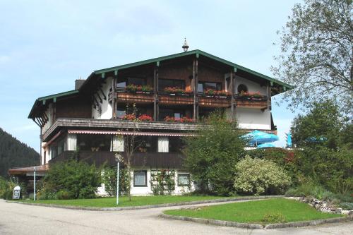 a large building with flower boxes on the balcony at Landhotel Maiergschwendt inkl Chiemgaukarte in Ruhpolding