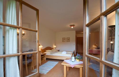 a bedroom with a bed and a large mirror at Landhotel Maiergschwendt inkl Chiemgaukarte in Ruhpolding
