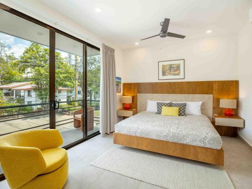 a bedroom with a bed and a yellow chair at Miram #4 - Three Bedroom Villa Across The Beach in Coco
