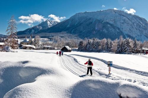 a person on skis in the snow in front of a mountain at Landhotel Maiergschwendt inkl Chiemgaukarte in Ruhpolding