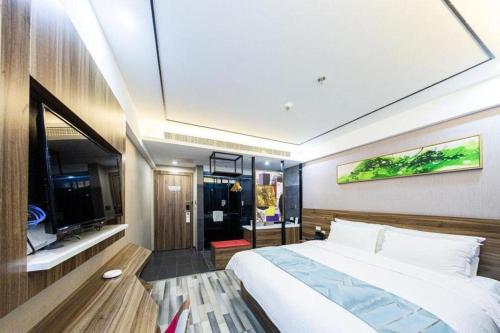 a bedroom with a large bed and a tv at Borrman Hotel Zhenjiang Dashikou Suning Plaza in Zhenjiang