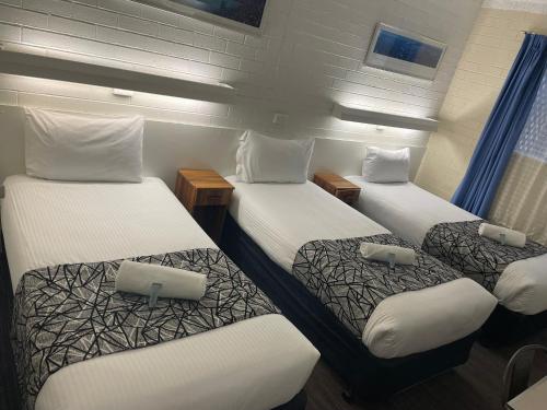 a room with three beds in a ship at Coastal Bay Motel in Coffs Harbour