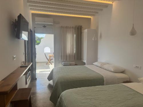 a hotel room with two beds and a television at Anais in Mýkonos City