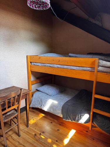 a bedroom with two bunk beds and a table at CHALET Tout Confort Proche d AX 3 Domaines in Vèbre