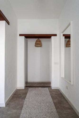 a hallway with white walls and a door with a rug at Max house in Teguise
