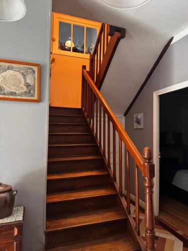 a staircase in a house with an orange door at CHALET Tout Confort Proche d AX 3 Domaines in Vèbre