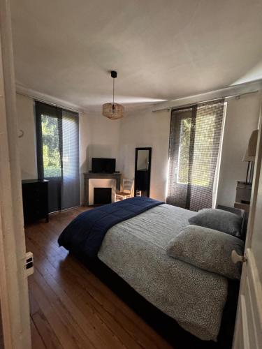 a bedroom with a bed and a desk and windows at CHALET Tout Confort Proche d AX 3 Domaines in Vèbre