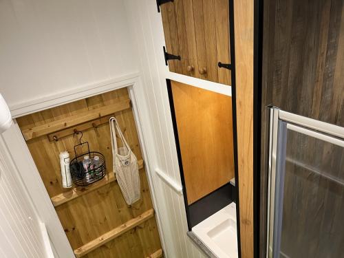 ein kleines Badezimmer mit einem Schrank mit Holzvertäfelung in der Unterkunft Doffers Cottage in Skipton