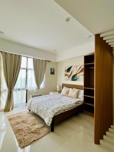 a bedroom with a bed and a large window at Raph Staycation near Mactan Newtown in Lapu Lapu City