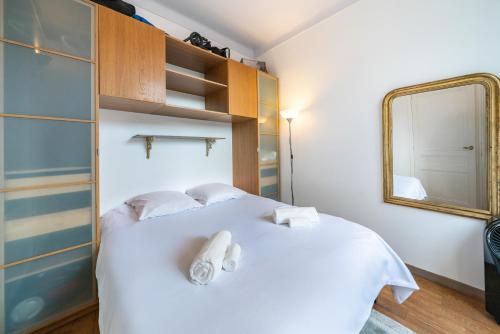 une chambre avec un lit blanc et un miroir dans l'établissement Au coeur du Suquet - 2 pièces cosy - Climatisation séjour, à Cannes