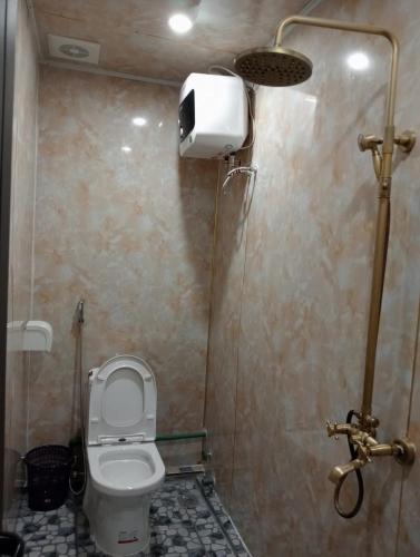 a small bathroom with a toilet and a shower at Xóm Mới HomeStay in Dồng Văn