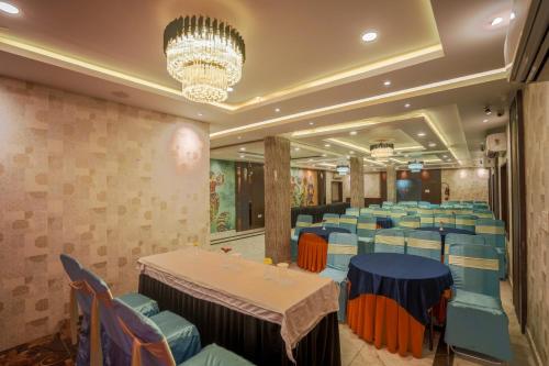 a restaurant with tables and chairs and a chandelier at HOTEL SJ PRIDE in Bhubaneshwar