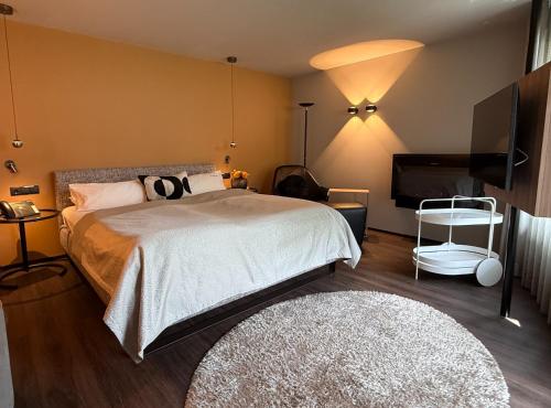 a bedroom with a bed and a flat screen tv at hirschen dornbirn - das boutiquestyle hotel - skyrelax & wellness im rooftop in Dornbirn