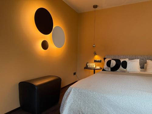 a bedroom with a bed with two mirrors on the wall at hirschen dornbirn - das boutiquestyle hotel - skyrelax & wellness im rooftop in Dornbirn