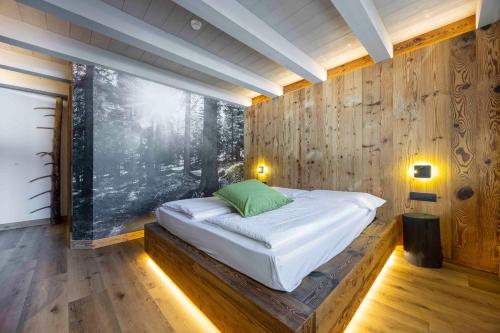 a bedroom with a bed in a wooden wall at Hotel Miralago in Misurina