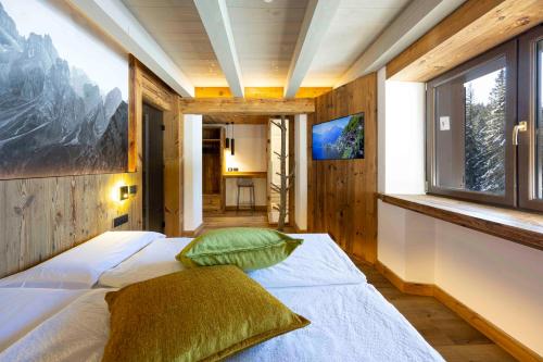 a bedroom with a bed and a window at Hotel Miralago in Misurina